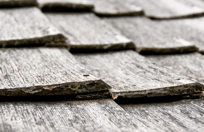 Close-up of a weathered slate roof with textured, overlapping tiles, ideal for home improvement projects.